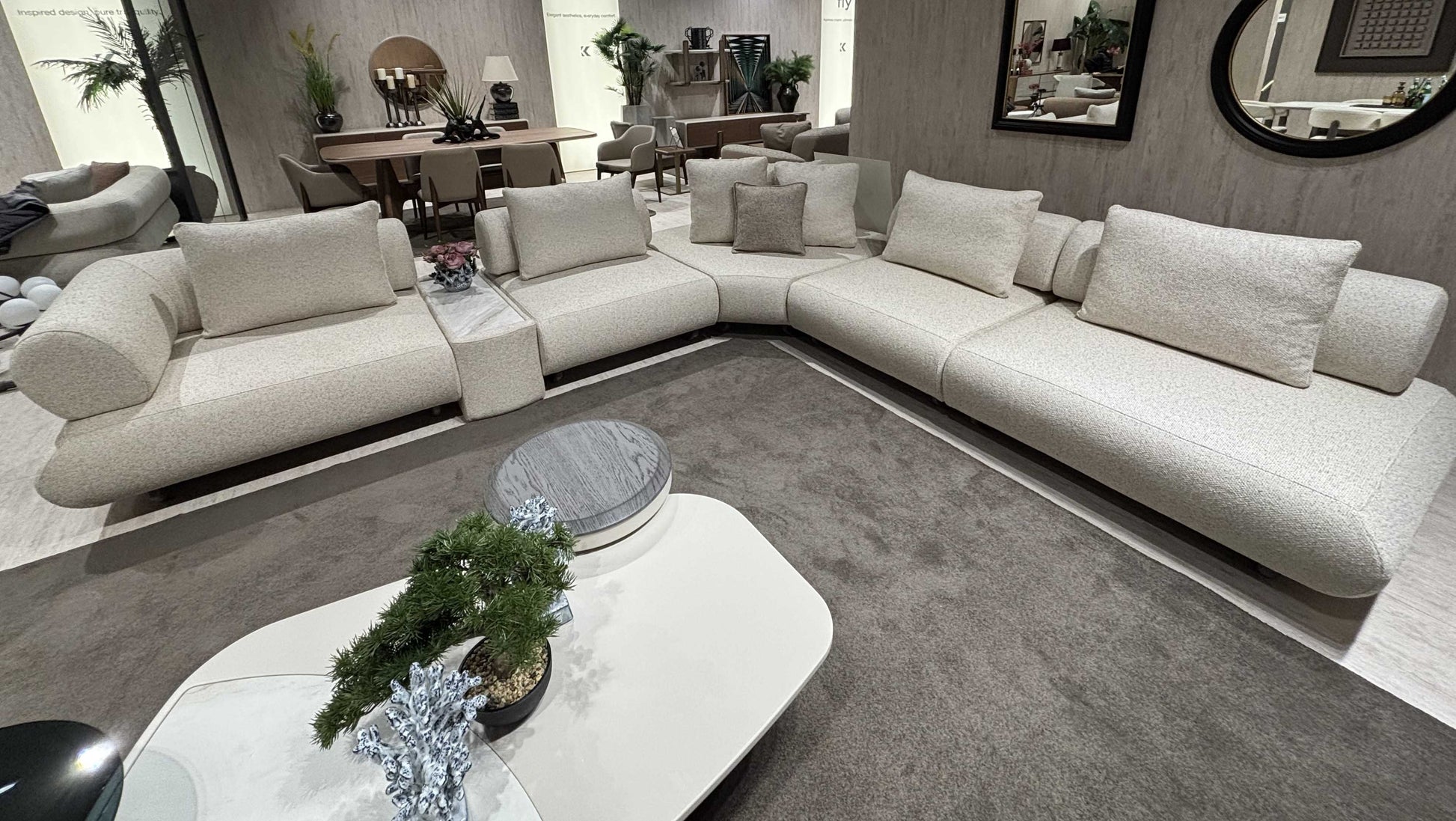 Salon moderne avec canapé Hermes en L, tables basses design et décoration élégante, ambiance chaleureuse et raffinée